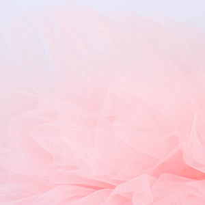 Dettaglio macro del tessuto in tulle rosa chiaro per abiti da festa da donna in rete