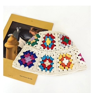 Close-up of handmade crochet bucket hat with colorful flower patterns on beige cotton
