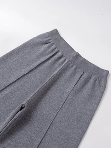 Détail du pantalon large en tricot gris montrant la taille élastique et les coutures déco
