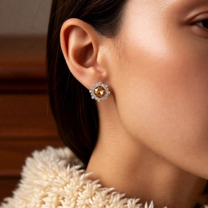 Close-up of vintage sunflower stud earring with amber crystal and 18k gold plating