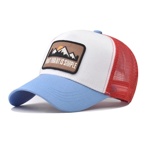 Dettaglio del cappello trucker in mesh blu, bianco e rosso con ricamo di montagna