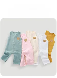 Flat lay of cotton gauze baby bodysuits in various colors with cute bear embroidery