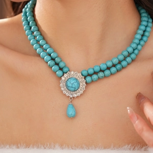 Detailed close-up of a double-layer turquoise beaded necklace with a crystal pendant