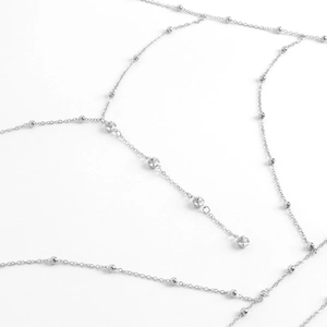 Macro shot of silver body chain featuring sparkling crystal pendants on white background