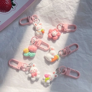 Flat lay view of cute pink carrot bunny keychains with flower charms for backpacks