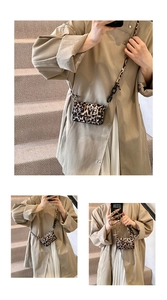 Detail view of mini leopard print crossbody bag with chain strap and metal buckle closure