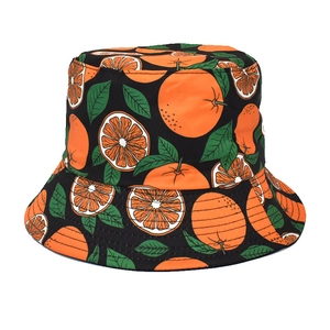 Détails rapprochés des motifs d'oranges et de feuilles vertes sur un chapeau bob noir