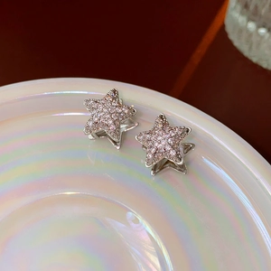 Macro view of silver star earrings with micro-paved cubic zirconia crystals