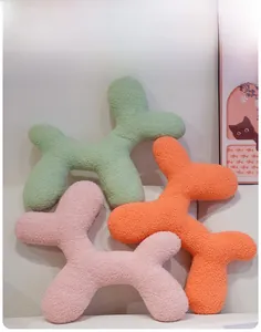 Detailed texture of colorful sherpa balloon dog plush pillows on a white sofa