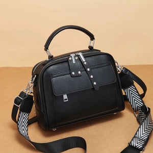 Borsa a tracolla moderna in pelle martellata nera con hardware argento e tracolla in tessuto