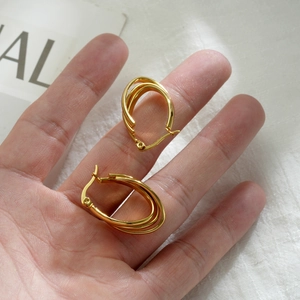 Close-up of golden multi-layer triple hoop earrings made of high-quality stainless steel