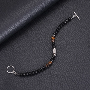 Detail of 6mm obsidian and tiger eye beaded bracelet with steel T-bar clasp on leather
