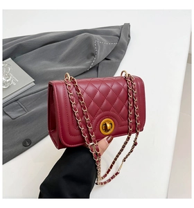 Close-up of wine red quilted crossbody bag with gold-tone metal twist lock detail