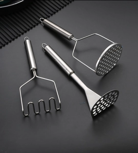 Three stainless steel potato mashers with wavy and perforated heads on black background