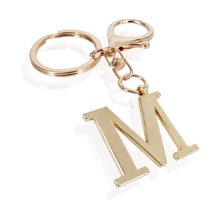 Detailed macro view of high-polish gold-plated metal letter M keychain with lobster clasp