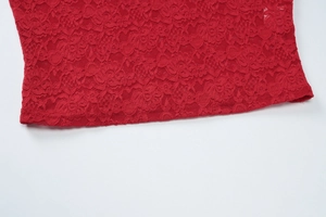 Gros plan sur la dentelle rouge montrant les motifs floraux et la texture ajourée