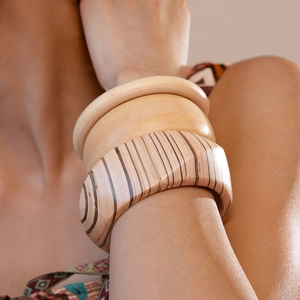 Close-up of three vintage wooden geometric cuff bracelets showing natural wood grain textures