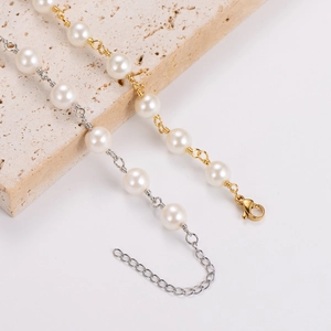 Handmade baroque pearl bracelets in gold and silver finishes on a stone display