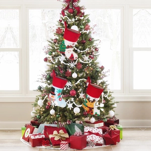 Three colorful Christmas stockings with Santa and snowman hanging on a festive tree