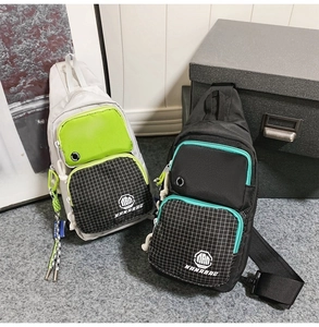 Close-up of two waterproof nylon chest bags in gray and black with vibrant green accents