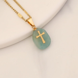 Detailed shot of a turquoise gemstone pendant with an inlaid golden cross on a chain