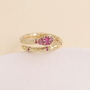 Detailed view of gold snake ring featuring vibrant pink micro-set cubic zirconia stones