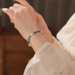 Titanium steel bracelet with blue gemstones and freshwater pearls on female wrist