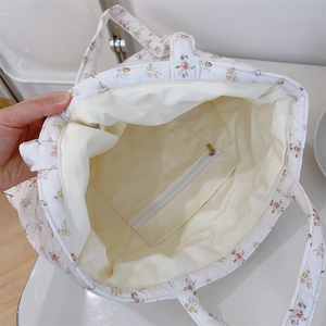 Détail de l'intérieur du sac fourre-tout fleuri avec poche zippée et doublure en toile