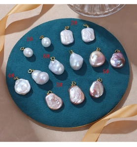 Detailed macro view of baroque pearl pendants in white and pink with gold clasps