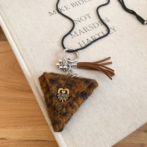 Detail of plush leopard print triangle pendant with silver ring and leather tassels