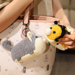 Cute plush husky and bee animal keychain charms hanging on a pink handbag