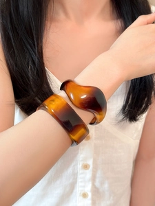 Close-up of irregular amber acrylic resin bracelets with a vintage tortoiseshell texture
