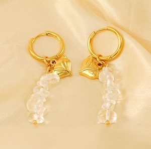 Detailed view of fox head gold earrings with white crystal stones on silk background