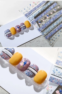 Détail d'autocollants 3D pour ongles avec oiseaux bleus et motifs floraux roses