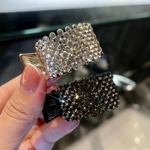 Close-up of sparkling rhinestone hair clips with silver metal base in rectangular shape