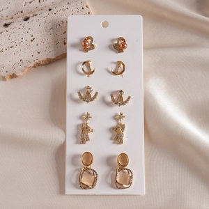 Close-up of 5-pair gold earring set with pearls and rhinestones on display card