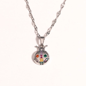 Detail view of a silver ladybug pendant featuring colorful rhinestones on a delicate chain