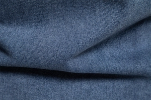 Gros plan sur la texture en sergé de denim bleu foncé pour chemise décontractée homme