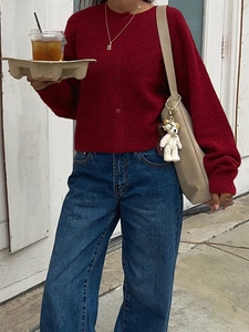 Women's casual burgundy knitted cardigan and denim wide-leg jeans outfit with tote bag