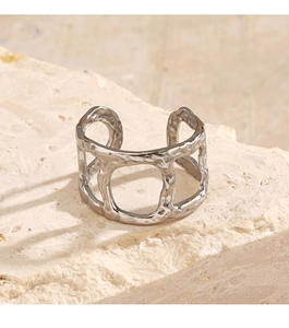 Detailed view of silver hammer-textured open ring on minimalist stone background