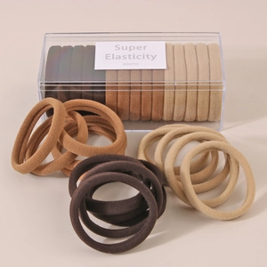 Detail of high-elastic hair bands in earthy tones stored in a clear plastic organizer box
