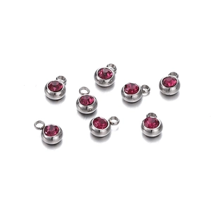 Vue détaillée de sept pendentifs argentés sertis de pierres de zircone rouges arrondies