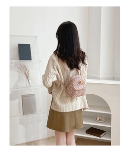Mini pink checkered backpack shown being worn by a model in a modern lifestyle setting