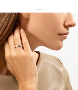Close-up of a delicate 925 sterling silver ring featuring a continuous heart-shaped pattern
