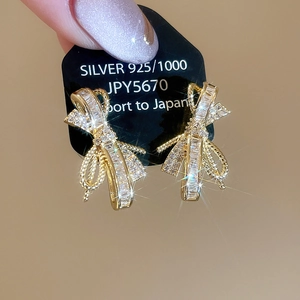 Macro view showing sparkling zircon bow earrings with 925 silver gold plated posts