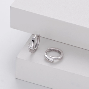 Macro shot of 925 silver geometric hoop earrings with sparkling round zircon stones