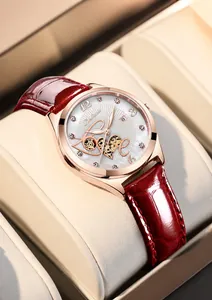 Dettaglio di un elegante orologio da donna in oro rosa con cinturino in pelle rossa