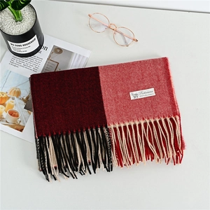 Detail of red and coral cashmere scarf showing fine twill weave and elegant fringe edges