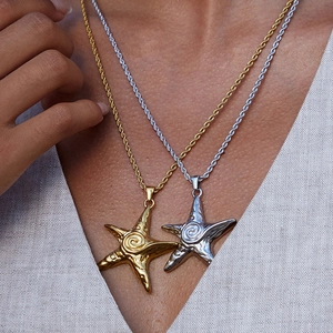 Detailed close-up of gold and silver starfish pendants with textured rope chains