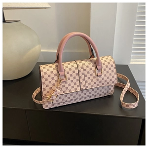 Detail of pink crossbody bag with geometric patterns and golden metal hardware